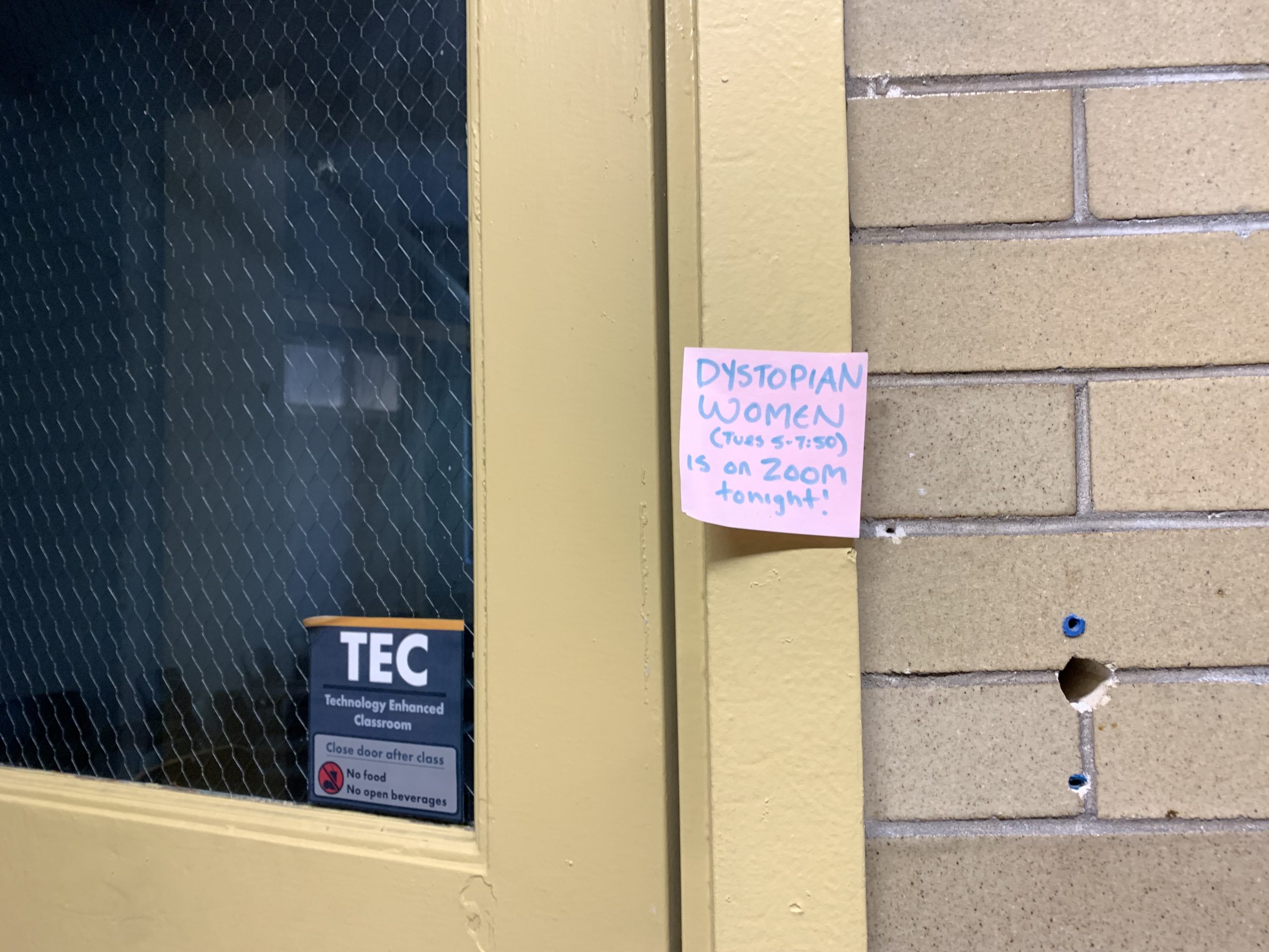 post-it note at classroom door at Pratt Institute in Brooklyn changing the location of the Dystopian Women's class to Zoom